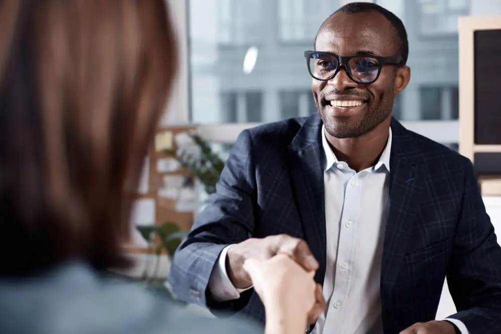 Young job candidate shaking hands with interviewer