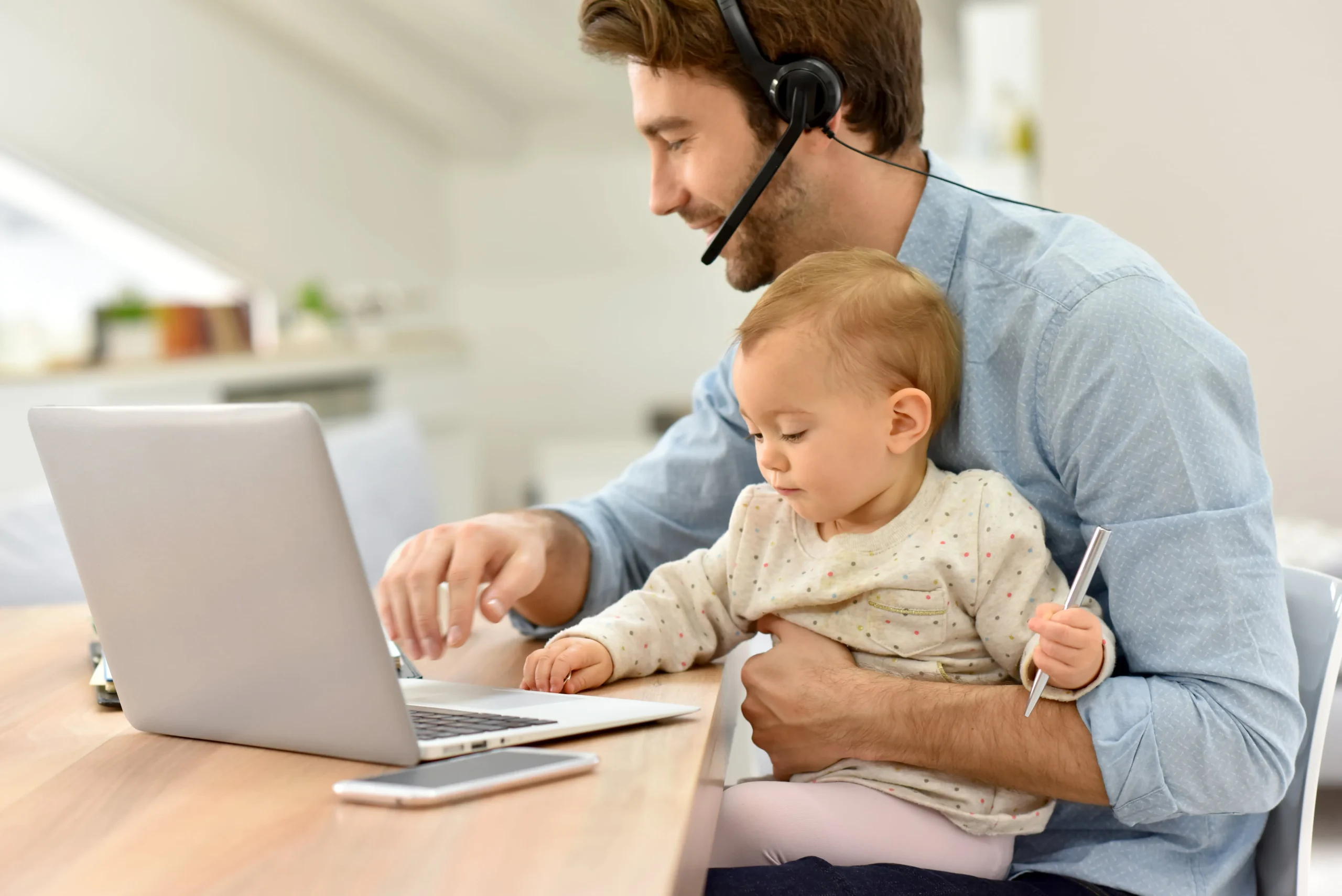Young professional working from home, with baby in lap